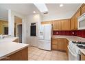 Bright kitchen features tile floors, white appliances, and an open layout with seamless flow to living spaces at 15313 W Pantano Dr, Surprise, AZ 85374