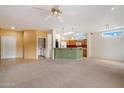 Spacious living area featuring carpet flooring, bright paint, and an open layout to the kitchen at 15313 W Pantano Dr, Surprise, AZ 85374