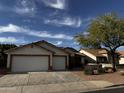 Charming home featuring a two-car garage, desert landscaping and solar panels on the roof at 15742 W Central St, Surprise, AZ 85374