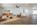 Bright, staged living room with stylish furniture, wood floors, and an open layout to the kitchen, perfect for modern living at 16008 N 69Th Ln, Peoria, AZ 85382