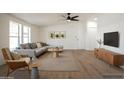 Comfortable living room with a gray sofa, accent chair, wood floors, and large windows offering plenty of natural light at 16008 N 69Th Ln, Peoria, AZ 85382