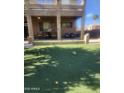 View of artificial grass, a covered patio with furniture, and outdoor decor at 1725 E Coconino Dr, Chandler, AZ 85249