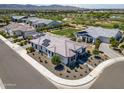 Stunning aerial view of a modern home featuring solar panels, landscaping, and a nearby golf course community at 17376 W Wildwood St, Surprise, AZ 85388