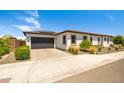 Charming single-story home with a two-car garage, brick driveway, and desert landscaping in a sunny, suburban setting at 17376 W Wildwood St, Surprise, AZ 85388
