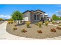 Beautifully landscaped front yard with decorative stone and mature trees framing this attractive single-Gathering home at 17376 W Wildwood St, Surprise, AZ 85388