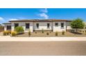 Attractive single-story home featuring desert landscaping, light stucco, and dark trim set against a bright, sunny sky at 17376 W Wildwood St, Surprise, AZ 85388