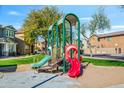 Vibrant community playground with slides and play structures, surrounded by well-maintained landscaping and charming homes at 17802 N 114Th Ln, Surprise, AZ 85378