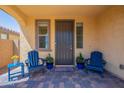 Cozy front porch featuring a tiled floor, two blue Adirondack chairs, and a welcoming atmosphere at 22184 N 101St Dr, Peoria, AZ 85383