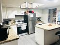 Functional kitchen with white cabinets, stainless steel appliances, and stylish countertops at 2377 W Hazelwood St, Phoenix, AZ 85015