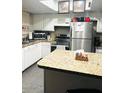 Functional kitchen with white cabinets, stainless steel appliances, and stylish countertops at 2377 W Hazelwood St, Phoenix, AZ 85015