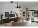 Bright living room featuring a unique ceiling fan, stylish decor, and sliding glass doors for natural light at 2916 E Sells Dr, Phoenix, AZ 85016