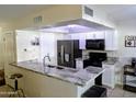 Modern kitchen featuring stainless steel appliances, granite countertops, and white cabinetry at 2927 N Oregon St # 7, Chandler, AZ 85225