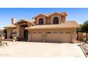 Charming home boasts a tile roof, mature landscaping, and a spacious three-car garage at 3538 E Squawbush Pl, Phoenix, AZ 85044