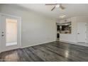 Open floorplan living room features wood flooring, ceiling fan, and access to the kitchen at 5302 E Van Buren St # 3040, Phoenix, AZ 85008