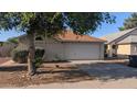 Well-maintained home showcasing a two-car garage, complemented by a mature tree, driveway, and cozy curb appeal at 537 E Piute Ave, Phoenix, AZ 85024