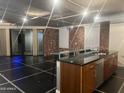 Modern kitchen featuring a glass countertop and stainless steel appliances, accentuated by brick walls at 6803 E Main St # 4415, Scottsdale, AZ 85251