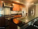 Modern kitchen featuring stainless steel appliances, wooden cabinetry, and black countertops at 6803 E Main St # 4415, Scottsdale, AZ 85251