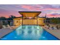 Beautiful pool featuring a covered structure, bar seating, lounge chairs, and blue LED lighting at 7130 E Navarro Way, Scottsdale, AZ 85266