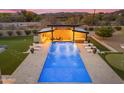 Overhead view of resort-style pool with a pergola, lounge chairs, putting green, and desert landscaping at 7130 E Navarro Way, Scottsdale, AZ 85266
