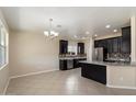 Stylish kitchen with granite countertops, dark cabinets, and stainless steel appliances, adjacent to living area at 737 E Harwell Rd, Phoenix, AZ 85042