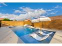 Sun-soaked pool featuring built in tanning ledge and umbrella, perfect for cooling off on a hot day at 7829 W Warner St, Phoenix, AZ 85043