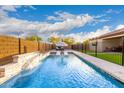 A backyard pool with a waterfall feature and lounge chairs offers a relaxing outdoor space at 7829 W Warner St, Phoenix, AZ 85043