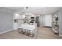 Eat-in kitchen featuring white cabinets, stainless steel appliances, and an island with seating at 7920 E Camelback Rd # 612, Scottsdale, AZ 85251