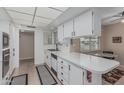 Functional kitchen features white cabinets, ample counter space and neutral tile flooring at 9606 W Long Hills Dr, Sun City, AZ 85351