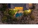 Aerial view of a backyard oasis featuring a pool, spa, outdoor kitchen, mature trees, and desert landscaping at 9936 E Winter Sun Dr, Scottsdale, AZ 85262