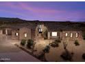 Stunning home exterior showcases desert landscaping, stone accents, and a tile roof under a vibrant sunset sky at 9936 E Winter Sun Dr, Scottsdale, AZ 85262