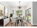 Bright dining room featuring a glass-top table, stylish light fixture, and a sliding door for seamless indoor/outdoor living at 11891 N 147Th Dr, Surprise, AZ 85379