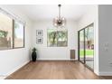 Dining area with decorative lighting, light hardwood floors, and large windows overlooking backyard at 11891 N 147Th Dr, Surprise, AZ 85379