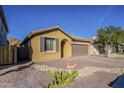 A single-story tan home with desert landscaping and a paver driveway at 13140 W Rowel Rd, Peoria, AZ 85383