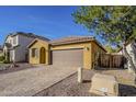 A tan stucco home with a two car garage and paver driveway at 13140 W Rowel Rd, Peoria, AZ 85383