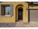 Inviting front entryway with dark door, shutters, desert landscaping and a charming tiled walkway at 13140 W Rowel Rd, Peoria, AZ 85383