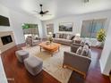 Bright living room with modern furnishings, a cozy fireplace, and large windows that provide ample natural light at 14065 W Cornerstone Trl, Surprise, AZ 85374