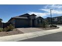 A well kept exterior with xeriscape landscaping, pavers and tile roof under a partly cloudy sky at 15301 W Moreland St, Goodyear, AZ 85338