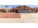 Charming single-story home featuring a three-car garage, desert landscaping, and a tile roof at 1625 E Daisy St, Casa Grande, AZ 85122