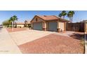 Exterior shot of a three-car garage with desert landscaping and mature palm trees in the background at 1625 E Daisy St, Casa Grande, AZ 85122