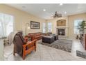 Spacious living room with a cozy fireplace, ceiling fan, and comfortable furniture at 16337 W Pierce St, Goodyear, AZ 85338