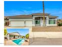 Inviting exterior view of the home with a three-car garage, well-manicured front yard, and charming desert landscape at 16398 N Oachs Dr, Surprise, AZ 85374