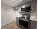 Gray cabinets, stainless steel appliances, and quartz countertops complete this modern kitchen at 1916 W Morningside Dr # 111, Phoenix, AZ 85023