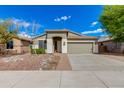 Charming home with a two-car garage and desert landscaping under a bright blue sky at 20713 N 91St Dr, Peoria, AZ 85382