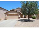 Two-story home featuring a two-car garage, desert landscaping, and a shade tree at 2434 E San Manuel Rd, San Tan Valley, AZ 85143