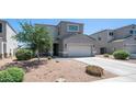 Beautiful home with a two-car garage, desert landscape, and mature trees at 33013 N Ash Tree Ln, San Tan Valley, AZ 85144
