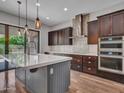 Well-lit kitchen featuring a large island, stainless steel appliances, and seamless access to the backyard at 3809 E Lynx Pl, Chandler, AZ 85249