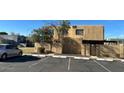 Beige condo with a tree, a short fence, a carport, and a car parked in front of the unit at 5416 W Hearn Rd, Glendale, AZ 85306