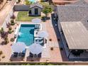Aerial shot of a private in-ground pool and patio with blue and white umbrellas and lounge chairs at 5919 S Newberry Rd, Tempe, AZ 85283