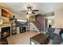 Inviting living room with a fireplace, ceiling fan, tile flooring, and staircase leading to the upper level at 7977 W Wacker Rd # 220, Peoria, AZ 85381
