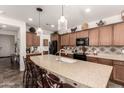 Well-appointed kitchen boasts granite countertops, stainless steel appliances, and a large island at 805 E La Palta St, Queen Creek, AZ 85140